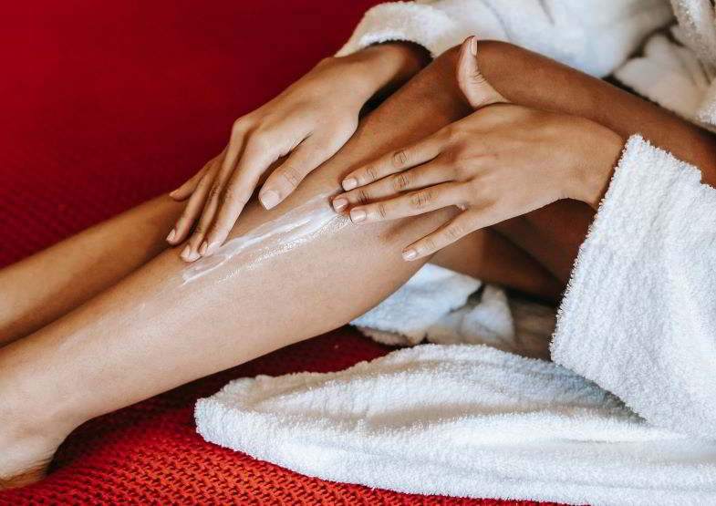 Woman spreading hemp cream on her legs