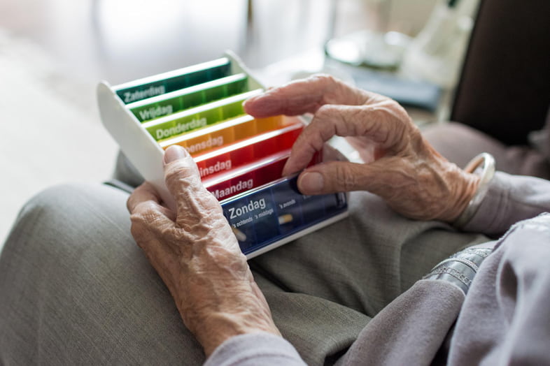 Elderly-person-checks-his-daily-medication Elderly person checks the medicines he/she has to take daily