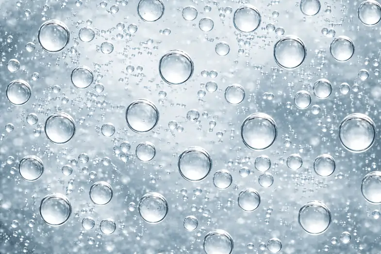 Macro view of oil droplets dispersed in water illustrating nanoemulsified CBD oil particle distribution. | Justbob