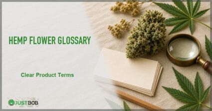 Justbob Hemp Flower Glossary banner with green title, hemp bud, stack of blank vocabulary cards, brass loupe and pencil