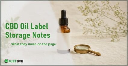 Justbob CBD Oil Label Storage Notes banner with green title, an amber dropper oil bottle with a blank pale label and a brass loupe on cream linen