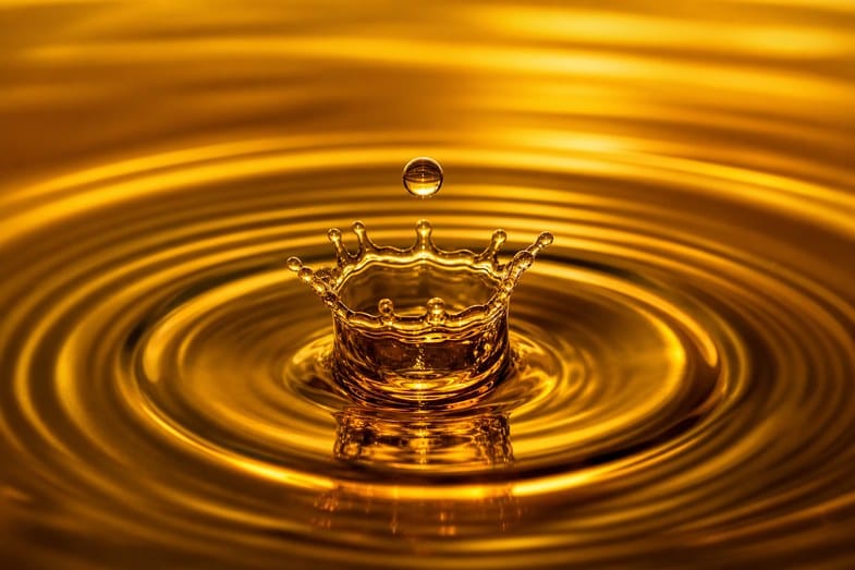 cbd-oil-concentration-documents A golden CBD oil drop falling into a pool of oil creating concentric ripples and a splash crown